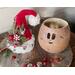 This image shows the Christmas elf hat sitting next to the carved elf gourd. Red and silver jingle bells lay next to the gourd display.